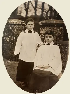 Vintage black and white sepia-toned photograph of two young boys, the Funnell brothers, dressed in historical choir robes outdoors.
